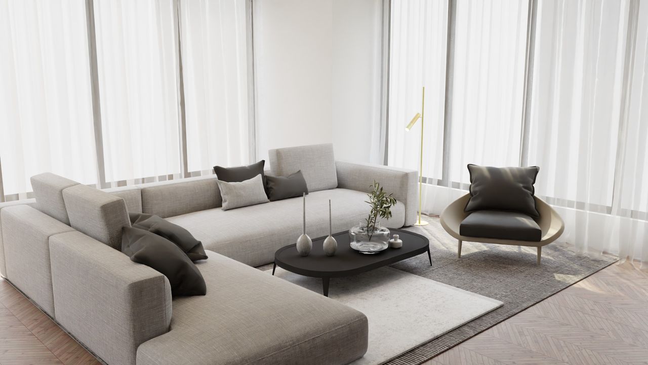 gallery-1 Elegant and cozy minimalist living room featuring a large gray sofa, armchair, and sleek coffee table.